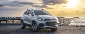 Chevrolet Trax parked in front of a sunny and cloudy sky.