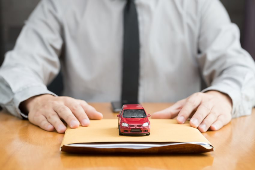 man with a paperwork folder and red toy car