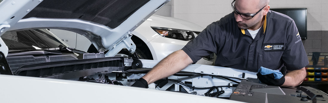 Man changing the oil on a Chevy